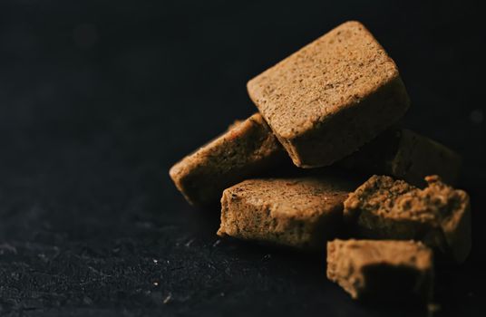 Vegetable bouillon cubes on stone kitchen board, stock or broth ingredient for soup, closeup