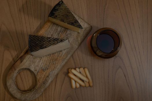 Cheese platter with wine and bread rolls