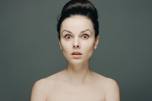 beautiful woman with bare shoulders clear skin collected hair emotions. High quality photo