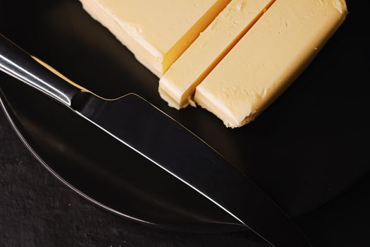 Sliced organic butter block and knife, breakfast food closeup