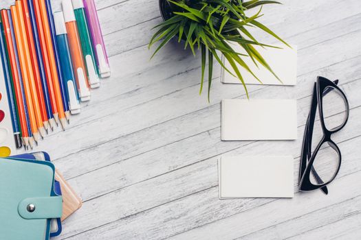 business cards on a wooden table and glasses of flowers in a pot office markers. High quality photo