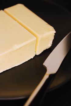 Sliced organic butter block and knife, breakfast food closeup