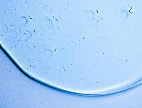 Blue gel texture on glass as cosmetics background, hygiene and science closeup