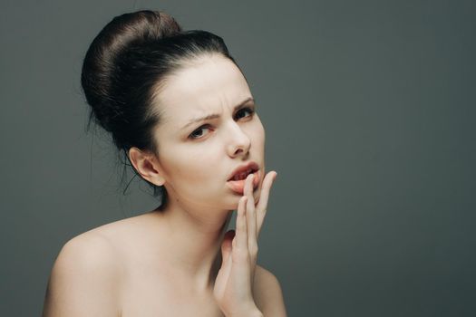 brunette with bare shoulders emotions glamor hand near face. High quality photo