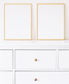 Two golden vertical frames on white furniture, luxury home decor and design for mockup creations