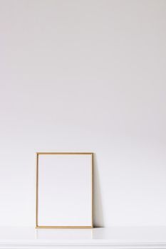 Golden vertical frame on white furniture, luxury home decor and design for mockup creations