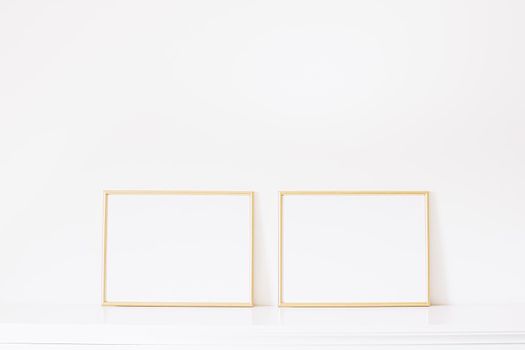 Two golden horizontal frames on white furniture, luxury home decor and design for mockup creations