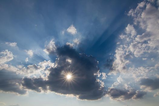 Sun behind the cloud with a hole - sun rays