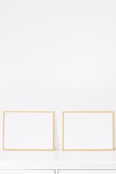 Two golden horizontal frames on white furniture, luxury home decor and design for mockup creations