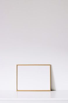 Golden horizontal frame on white furniture, luxury home decor and design for mockup creations