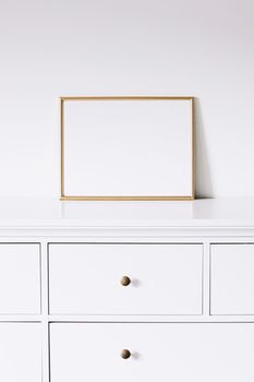 Golden horizontal frame on white furniture, luxury home decor and design for mockup creations