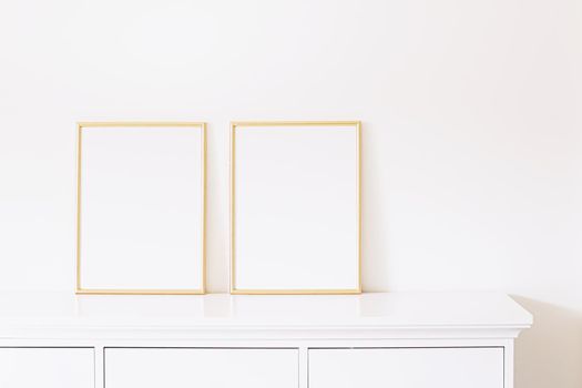 Two golden vertical frames on white furniture, luxury home decor and design for mockup creations