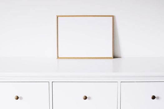 Golden horizontal frame on white furniture, luxury home decor and design for mockup creations