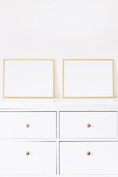 Two golden horizontal frames on white furniture, luxury home decor and design for mockup creations