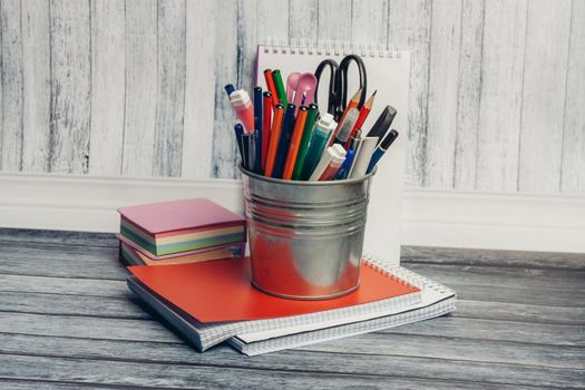 mug with stationery on notepad and wooden table in office. High quality photo