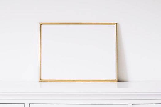 Golden horizontal frame on white furniture, luxury home decor and design for mockup creations