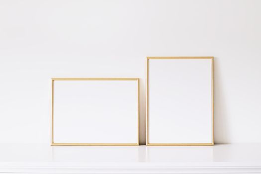 Two golden vertical and horizontal frames on white furniture, luxury home decor and design for mockup creations