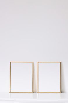 Two golden vertical frames on white furniture, luxury home decor and design for mockup creations