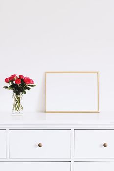 Golden horizontal frame and bouquet of rose flowers on white furniture, luxury home decor and design for mockup creations