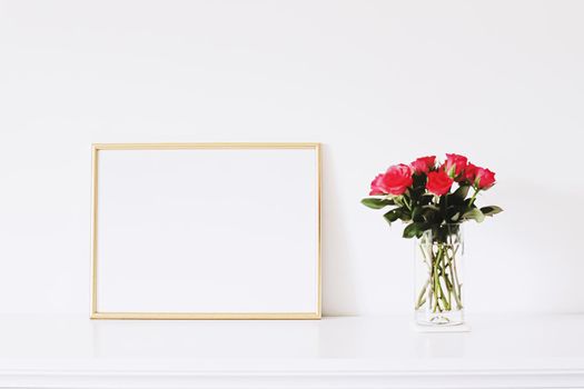 Golden horizontal frame and bouquet of rose flowers on white furniture, luxury home decor and design for mockup creations