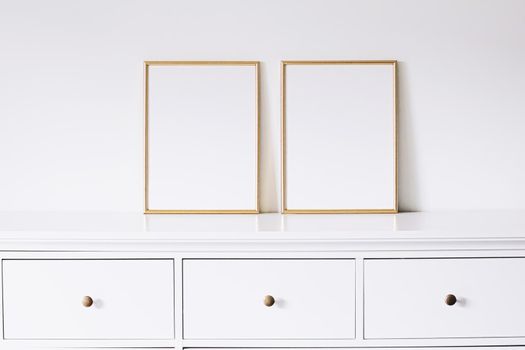 Two golden vertical frames on white furniture, luxury home decor and design for mockup creations