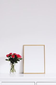 Golden horizontal frame and bouquet of rose flowers on white furniture, luxury home decor and design for mockup creations