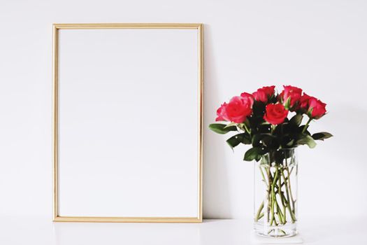 Golden horizontal frame and bouquet of rose flowers on white furniture, luxury home decor and design for mockup creations