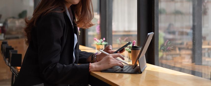 businessman working digital tablet and smartphone in coffee shop.