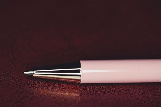 Pen and leather briefcase in office, closeup