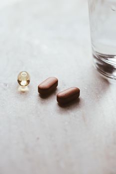 Medical pills and glass of water, health and wellness closeup