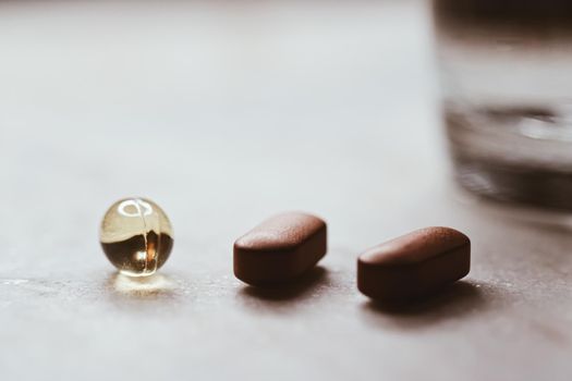 Medical pills and glass of water, health and wellness closeup