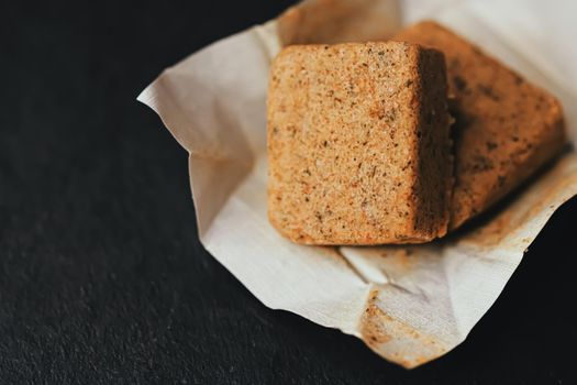 Vegetable bouillon cubes on stone kitchen board, stock or broth ingredient for soup, closeup