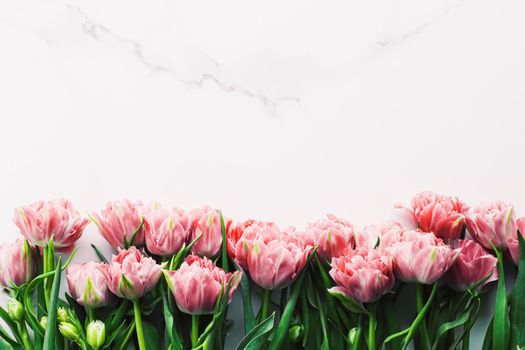 Spring flowers on marble background as holiday gift and floral flatlay concept