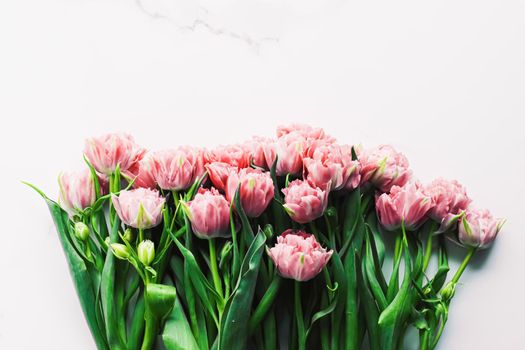 Spring flowers on marble background as holiday gift and floral flatlay concept