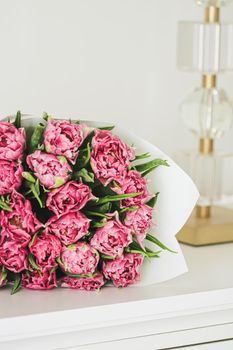 Bouquet of fresh cut pink tulips in an elegant interior, home decor closeup