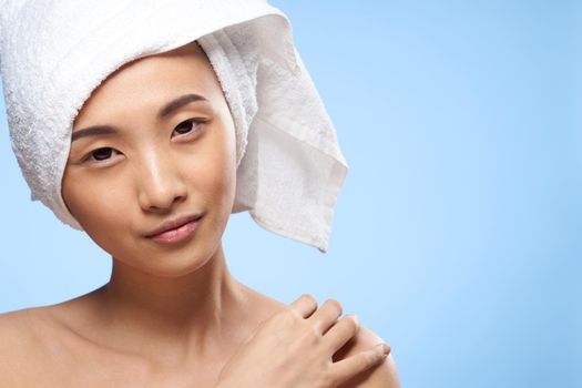 woman asian appearance naked shoulders clear skin health blue background. High quality photo