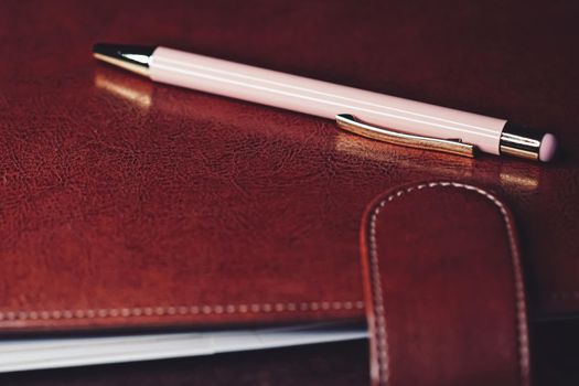 Pen and leather briefcase in office, closeup