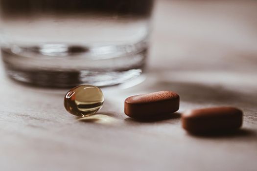 Medical pills and glass of water, health and wellness closeup