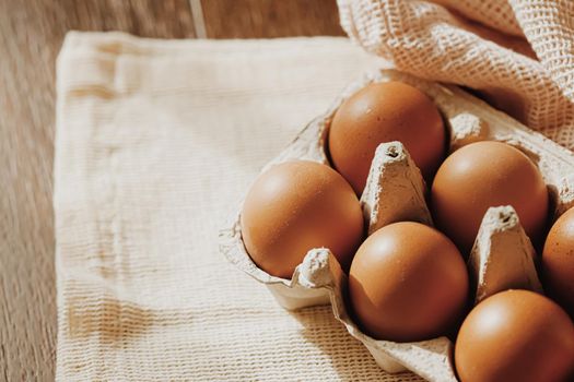 organic farm eggs in egg box and rustic cloth napkins, closeup