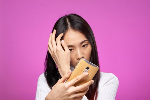 pretty woman with phone in hand internet technology messages pink background. High quality photo