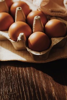 organic farm eggs in egg box and rustic cloth napkins, closeup