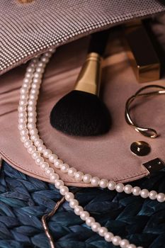 Jewellery and makeup tools inside a womans purse, beauty and fashion closeup