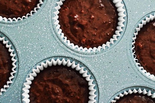 Chocolate muffin or cupcake batter in a pan ready to bake, homemade comfort food recipe concept