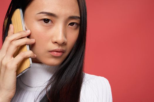 asian woman serious look phone communication technology close-up. High quality photo