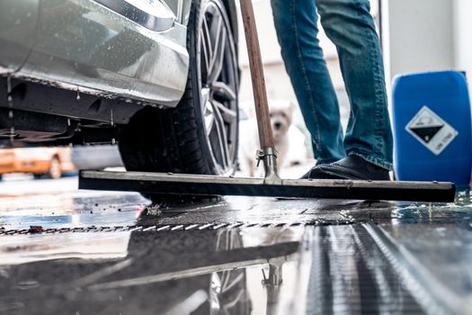 Clean the floor at the car wash with the help of a water spatula.