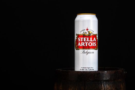 Can of Stella Artois beer on beer barrel with dark background. Illustrative editorial photo Bucharest, Romania, 2021