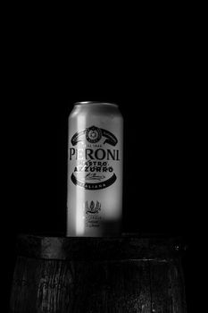 Can of Peroni beer on beer barrel with dark background. Illustrative editorial photo Bucharest, Romania, 2021