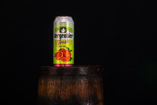 Can of Bergenbier beer on beer barrel with dark background. Illustrative editorial photo Bucharest, Romania, 2021