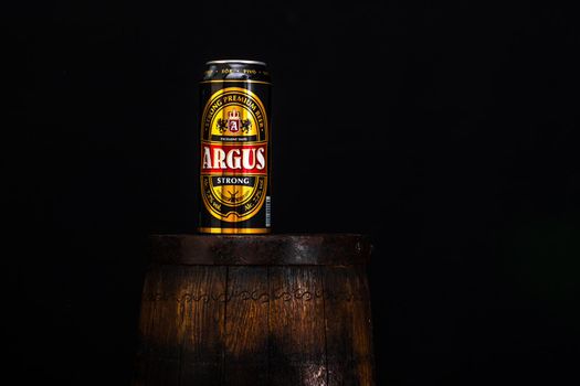 Can of Argus beer on beer barrel with dark background. Illustrative editorial photo Bucharest, Romania, 2021