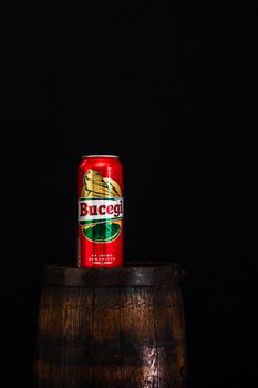 Can of Bucegi beer on beer barrel with dark background. Illustrative editorial photo shot in Bucharest, Romania, 2021